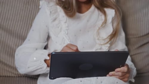 Girl Uses Tablet with Stylus Pen Indoors