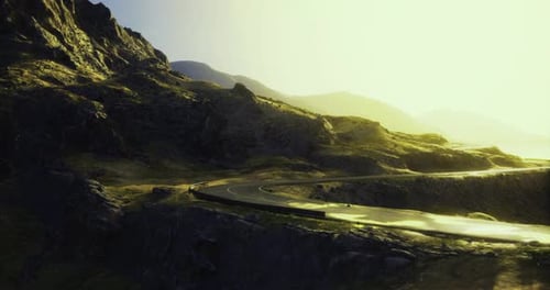 Scenic Winding Road Through Mountainous Terrain at Sunset with Golden Light