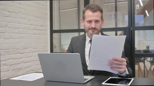 Focused Businessman Working with Laptop and Documents