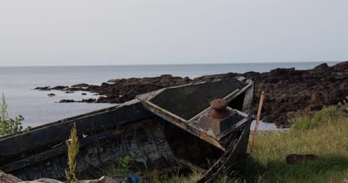 Mittelaufnahme eines verlassenen, verlassenen kaputten Bootes am alten Hafen bei Ebbe in Auchmithie