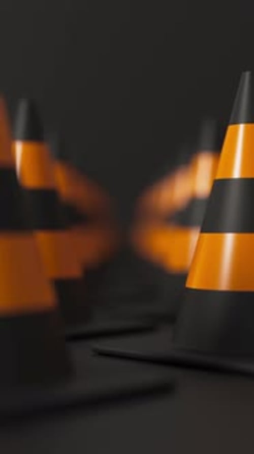Front View Grid of Traffic Cones in Orange and Black on a Black Background for Road Safety and