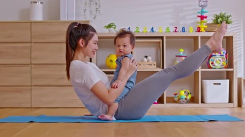 Mother Exercises Holding Her Baby in Living Room