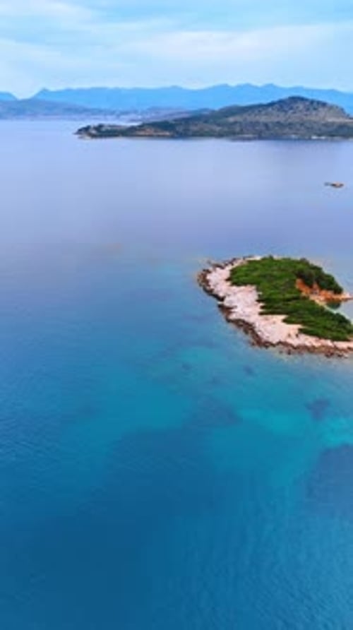 Turquoise waterscape with little islands surrounded by mountains.