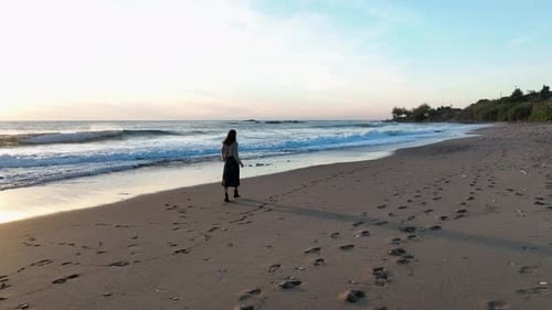 A Beautiful Girl Walks on the Beach of the Mediterranean Sea and Enjoys a Beautiful Sunset