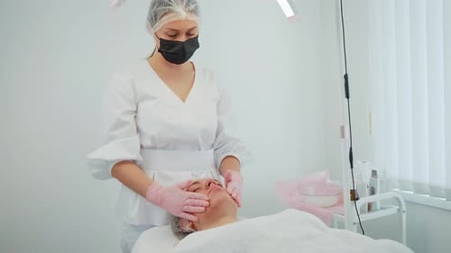 Woman Advising Correction Procedure During Skincare Consultation Female Assessing Facial Structure