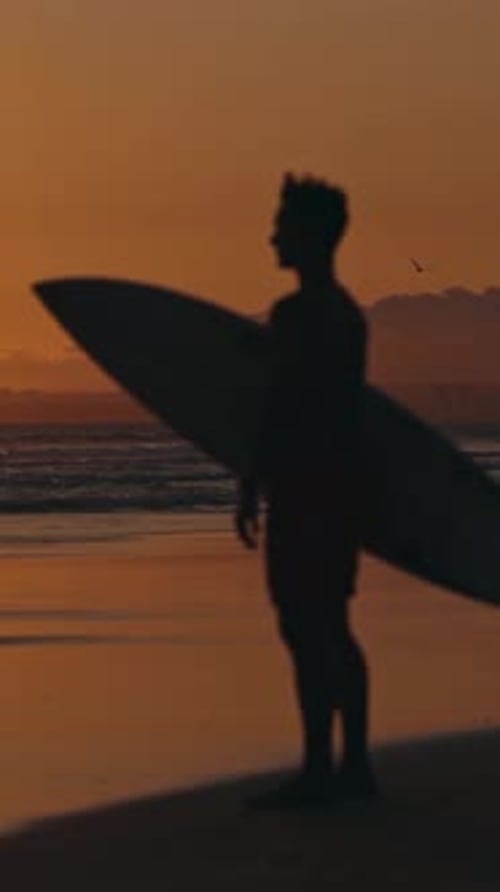 Verschwommene Silhouette eines nachdenklichen Surfers, der auf dem