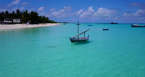 aerial view of a sailboat floating on the shallow turquoise waters of the Caribbean sea