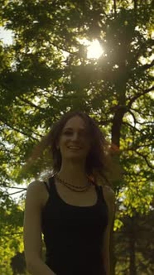 Vertical of Attractive Young Woman Turning to a Camera in Park