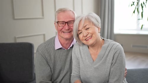 Smiling Senior Couple Embracing on a Couch