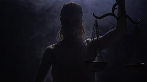 Dramatic Lady Justice Holding Scales in Dark Studio