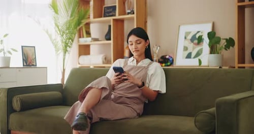 Woman Using Smartphone on Couch Indoors