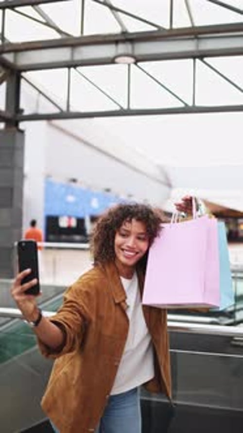 Jeune femme prenant un selfie après une virée shopping