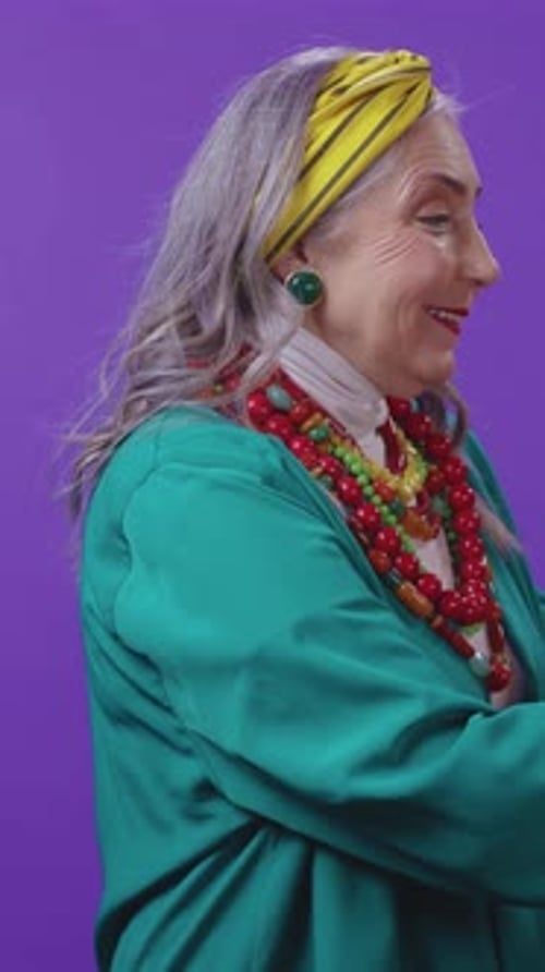 An Elderly Woman with Colorful Accessories and a Stylish Headband on a Purple Background