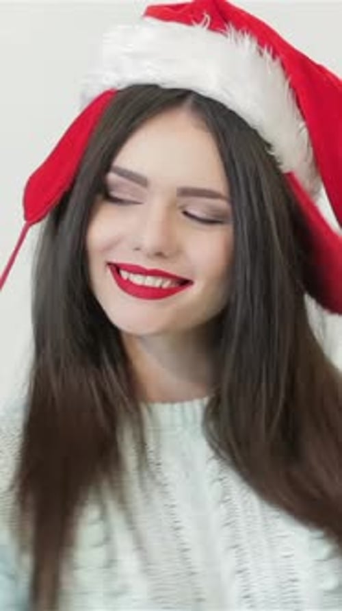 Festive Woman Wearing Santa Hat Smiling at Camera