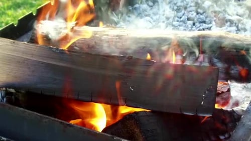 Burning wood in a barbecue grill outdoors
