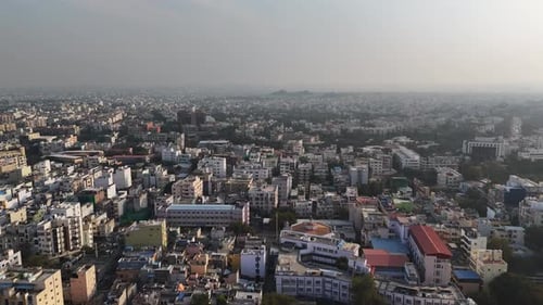 Cinematic aerial panorama of Hyderabad in winter, showcasing dense residential clusters, soft haze,