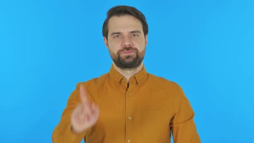 Stern Man Raises Finger in Disagreement on Blue