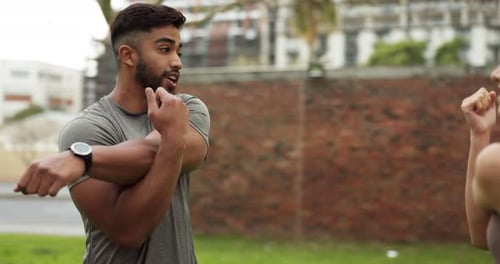 Man, woman and arm stretching in city fitness, workout and training with personal trainer