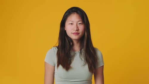 Young woman showing okay ok zero fingers gesture isolated on yellow background in studio