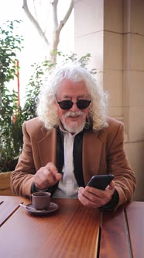 Adult Using Smartphone at Outdoor Cafe