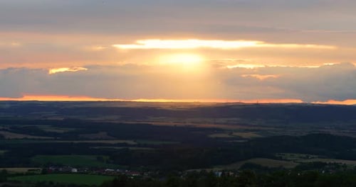 Die Sonne scheint bei Sonnenuntergang durch die Wolken und die Reflexion der Strahlen in die Landschaft