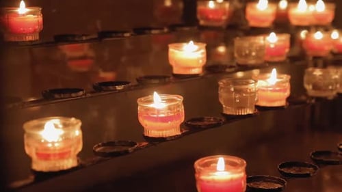 the camera moves around candles burning in the temple