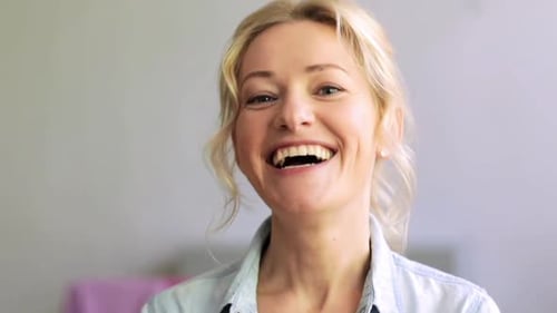 Happy young woman laughing with joyful expression in studio portrait