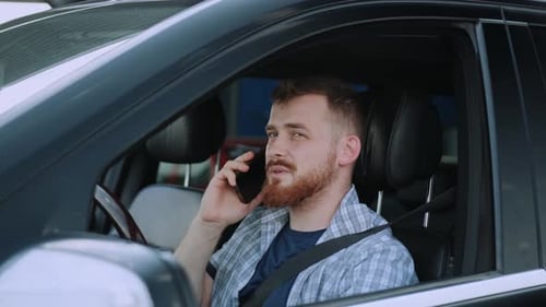 Man Talking on Phone While Sitting in Car
