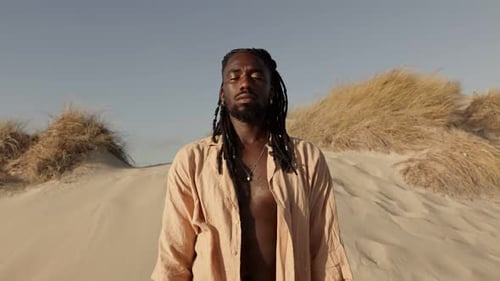 Man Meditating on Sandy Dune with Eyes Closed