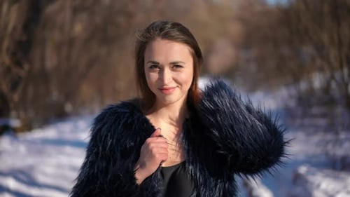 Coquette Belle jeune femme caucasienne en haut et manteau de fourrure posant au Ralenti sur un hiver ensoleillé