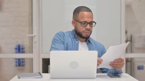 Young Adult Working at Laptop in Office