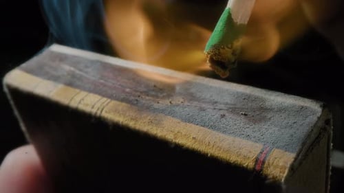 Hands Lights a Match with a Green Sulfur Head Slow Motion Strikes a Match on the Side of the Box