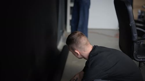 Man and Woman Collaborating, Adjusting Black Backdrop