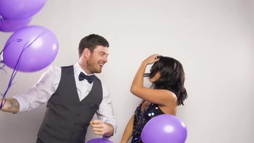Happy Couple Celebrates with Purple Balloons