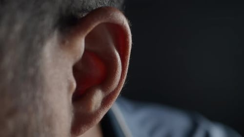 Close Up of Young Man Ear with a Yellow Background