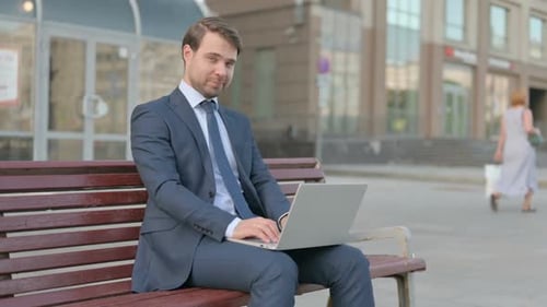 Young Adult Man Working on Laptop Outdoors