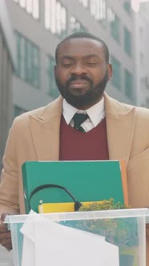 Sad Man Leaving Office With Box of Belongings