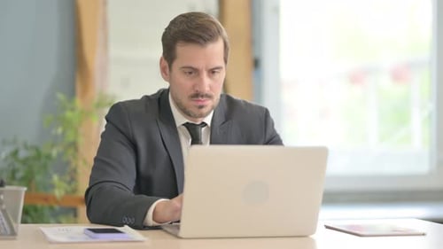 Businessman Leaving Office after Closing Laptop