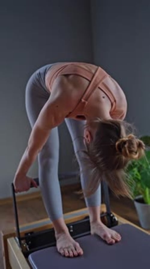 Woman Training Pilates on the Reformer Bed Reformer Pilates Studio Machine for Fitness Workouts in