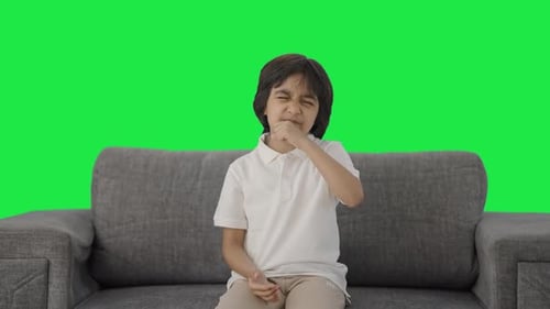 Sick Indian boy suffering from cold and cough Green screen