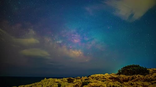 Milky Way galaxy moving across night sky with forming cloudscape, time lapse view