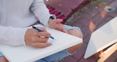 Nahaufnahme Video Künstlerin mit weiblichen Händen, die eine Kunst im Freien zeichnet