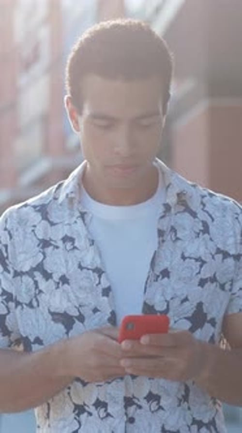 Young Man Uses Phone in City Setting