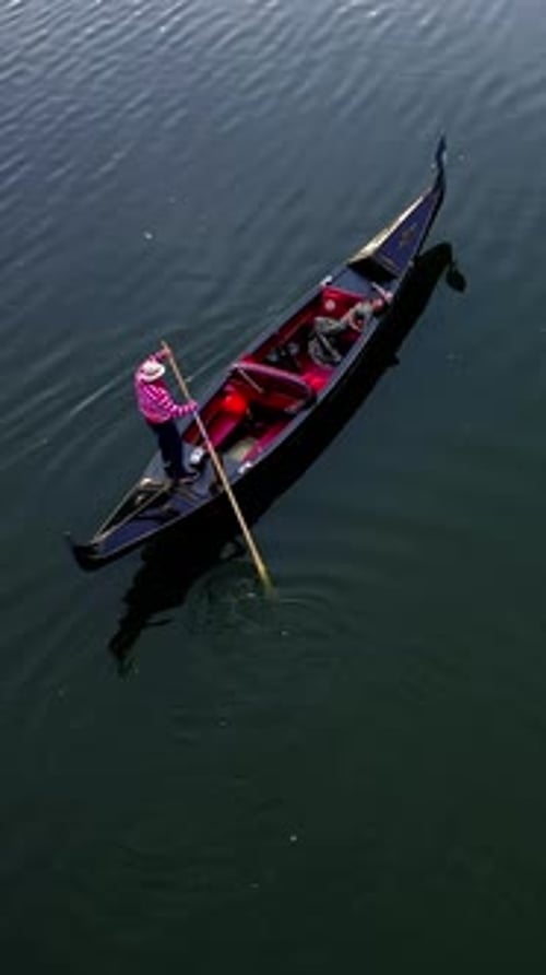 Gondola floating on water. Beautiful woman resting in a boat on the blue river at sunset.