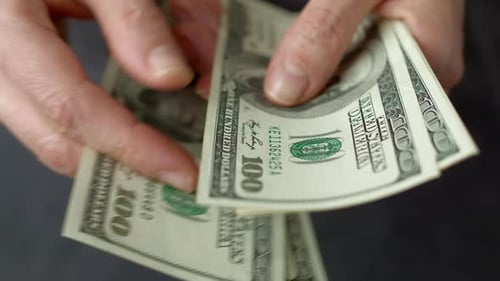 Close-up of one hundred dollar bills. American dollars are counted in hands. Money concept.