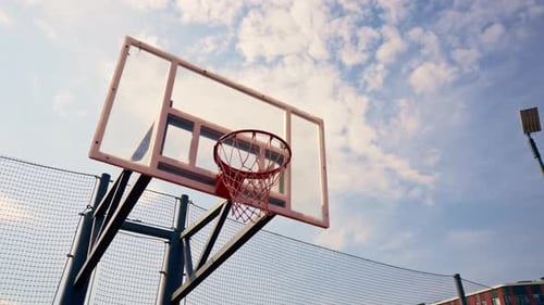 Tall guy basketball player jumps to the hoop with the ball in his hand to score a spectacular dunk