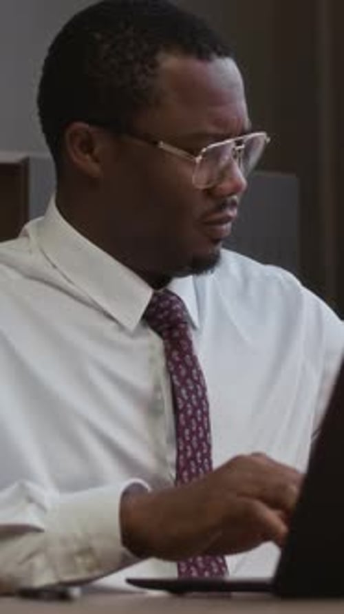 Employee Reviewing Paper at Office Desk, Vertical