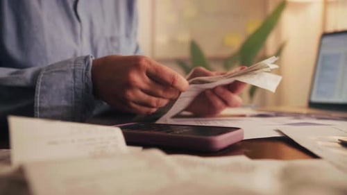 Woman Enters Expenses on Phone at Home Office