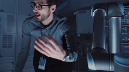 Senior Development Engineer is Explaining to His Colleague How the Futurisctic Robotic Arm Works an