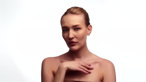 Studio Beauty Portrait of a Sexy Blonde Lady with Her Hair in a Bun Facing the Camera Softly